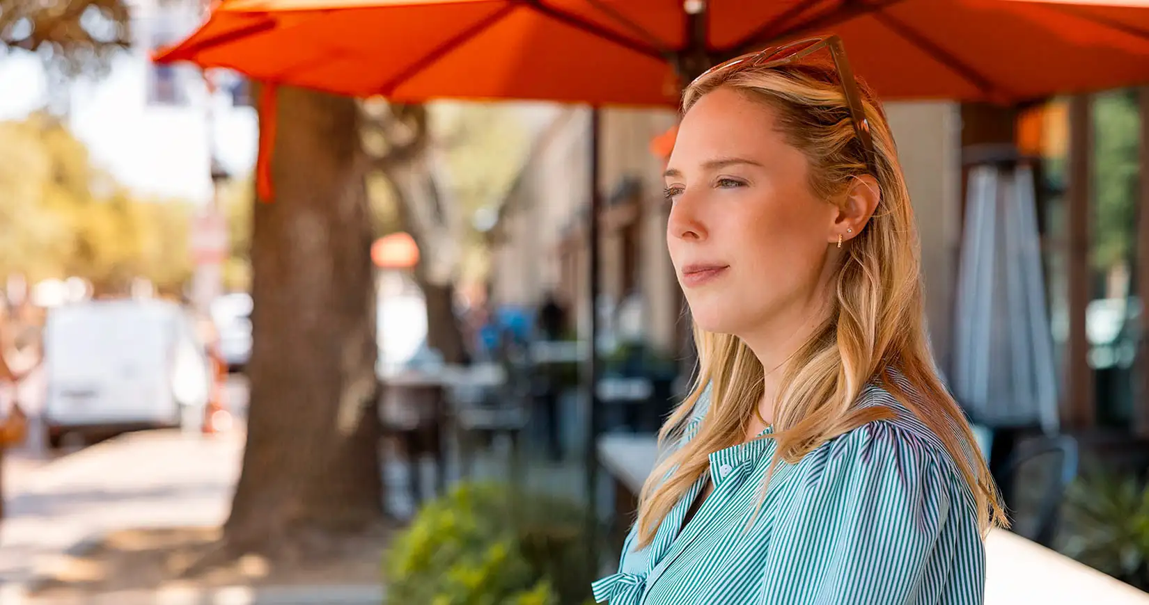 woman-at-outdoor-cafe-looking-away_web_tab_blade_full_background